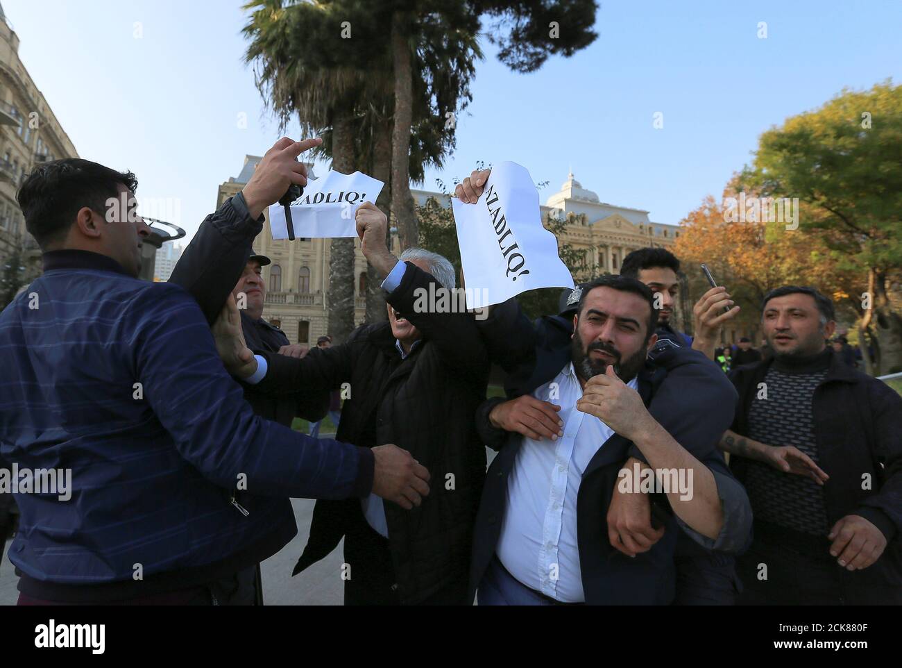 Azeri law enforcement officers detain participants of an unauthorized opposition rally to demand freedom of assembly in Baku, Azerbaijan November 12, 2019. The placards read 'Freedom!' REUTERS/Aziz Karimov Stock Photo