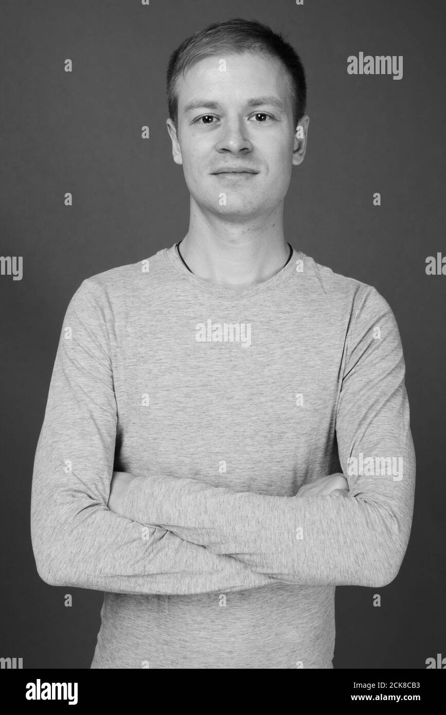 Portrait of young handsome man against gray background Stock Photo - Alamy