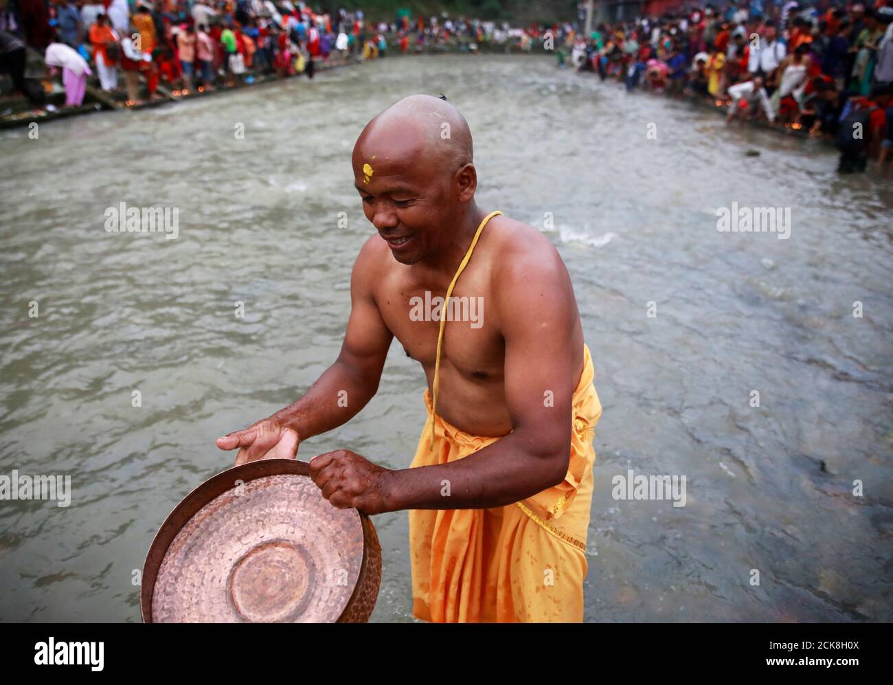 A Devotee Washes His Vessel After Performing Rituals On The Bagmati