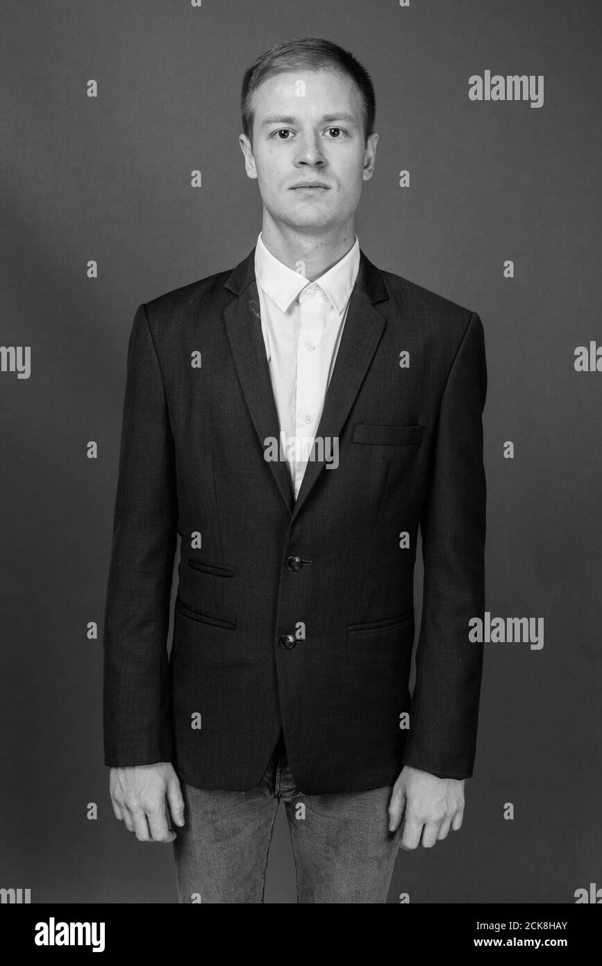 Portrait of young handsome businessman against gray background Stock ...