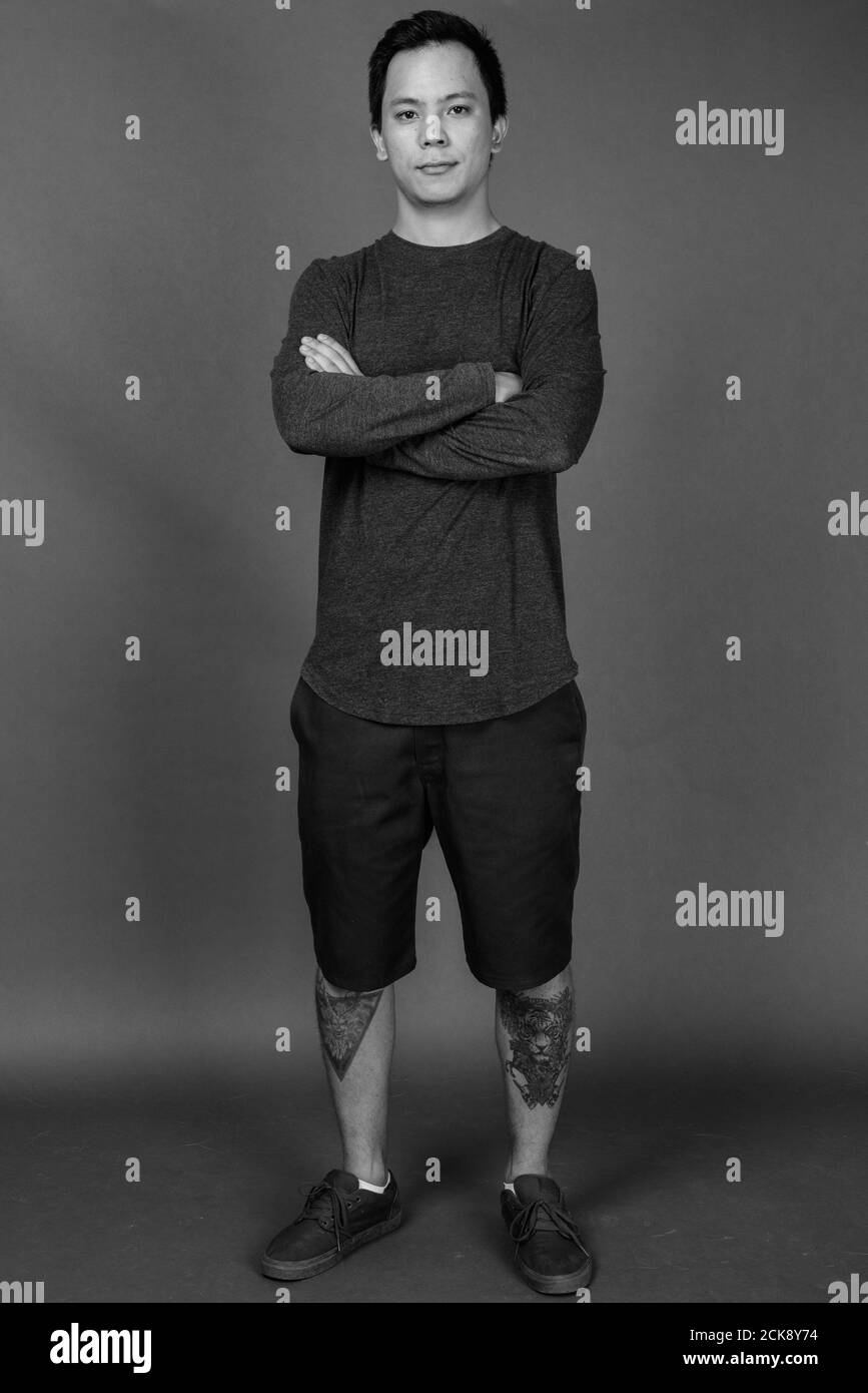 Portrait of young handsome man against gray background Stock Photo - Alamy
