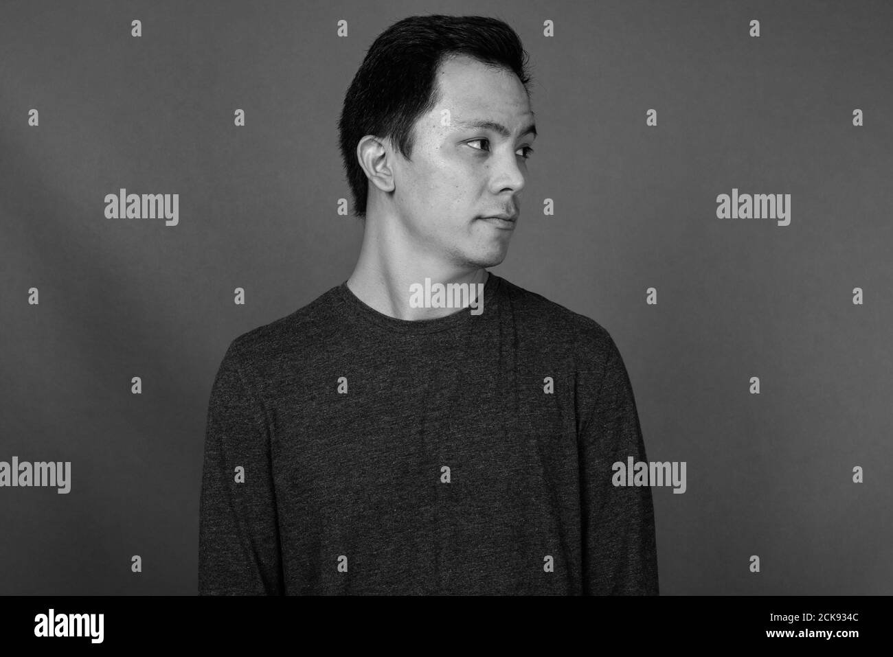 Portrait of young handsome man against gray background Stock Photo - Alamy