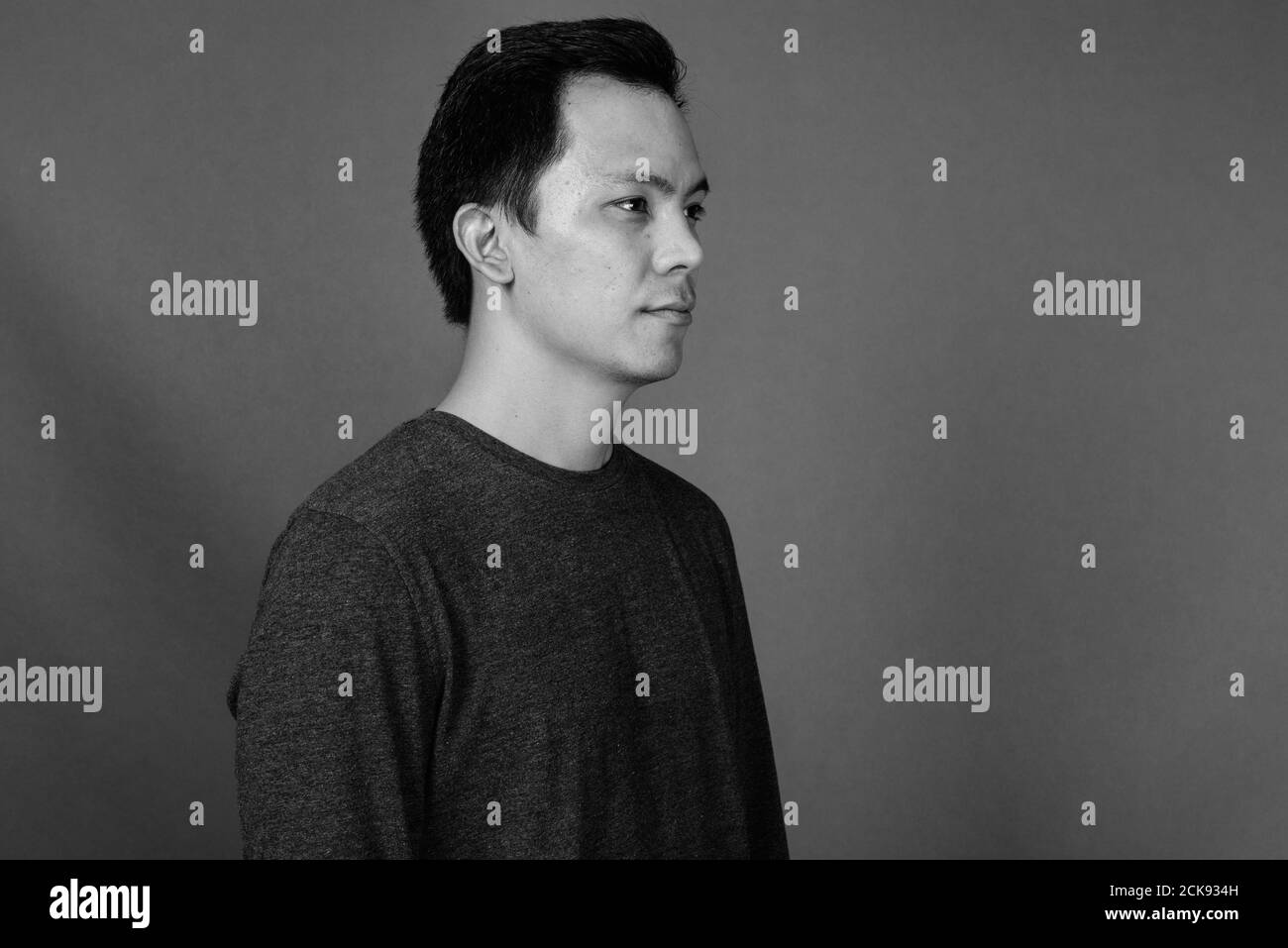 Portrait of young handsome man against gray background Stock Photo - Alamy