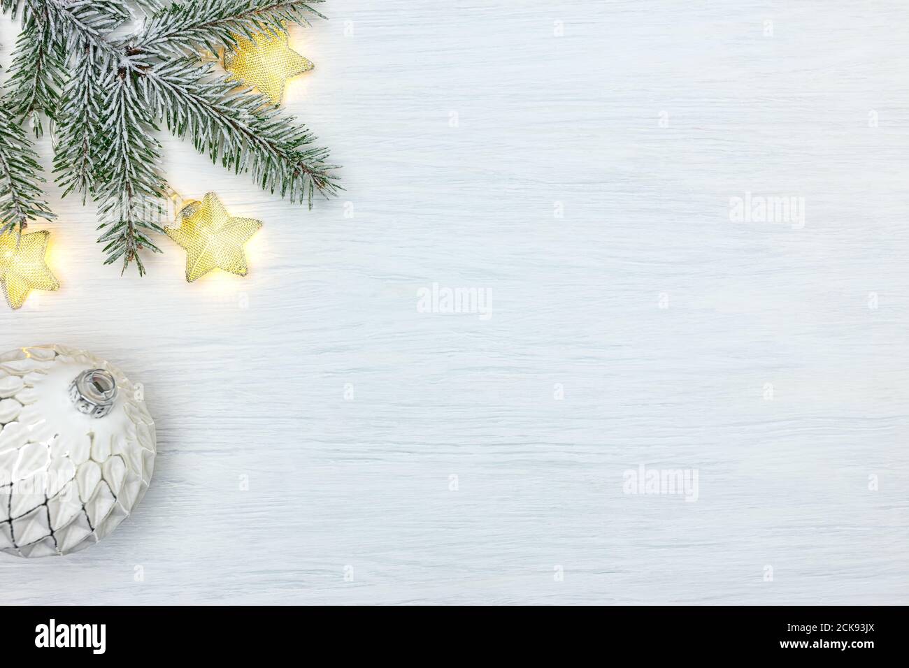 new year decoration - christmas tree branch, star lights garland and glass ball on white Stock Photo