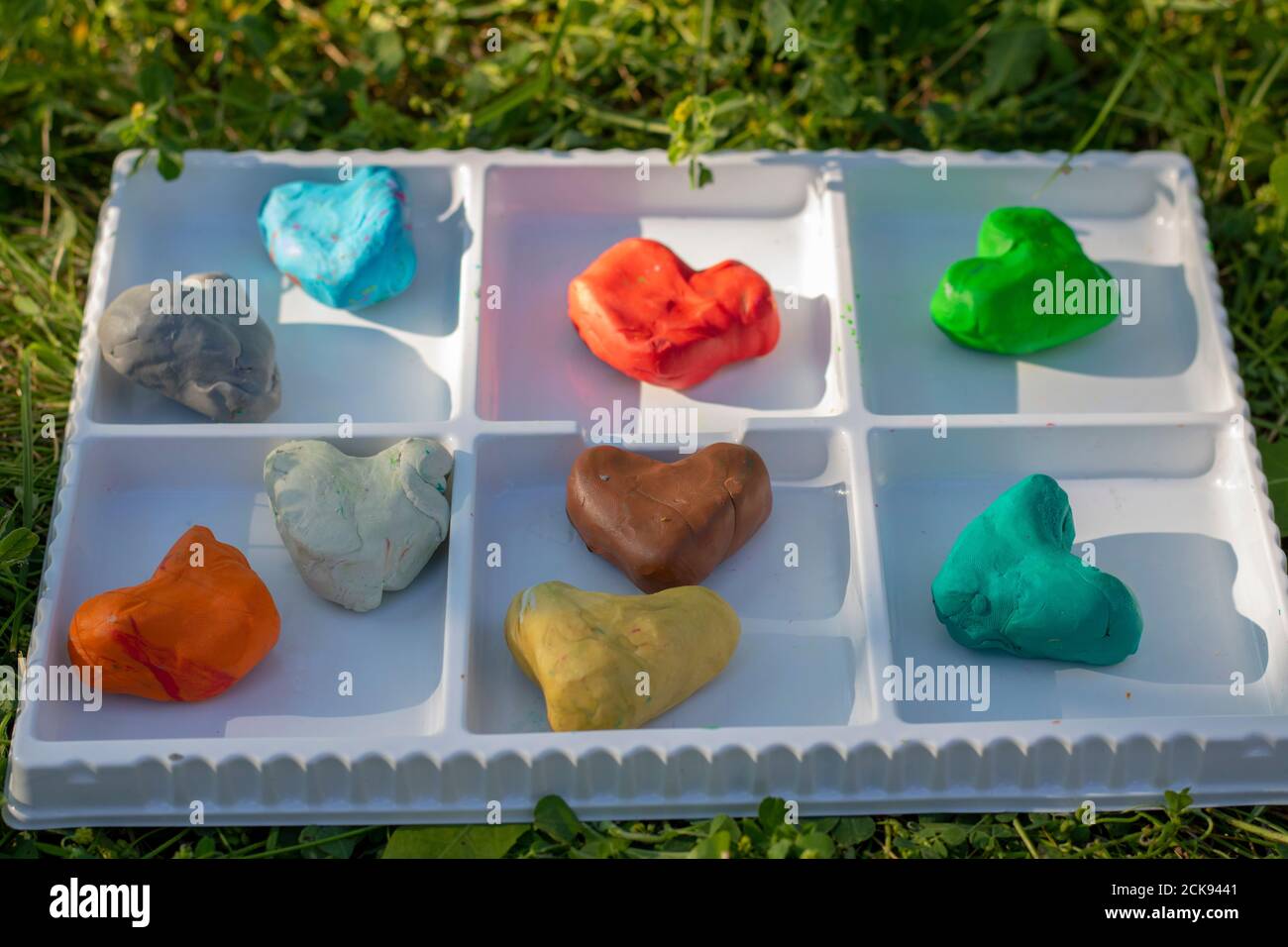 Many colored clay dough hearts in white box Stock Photo