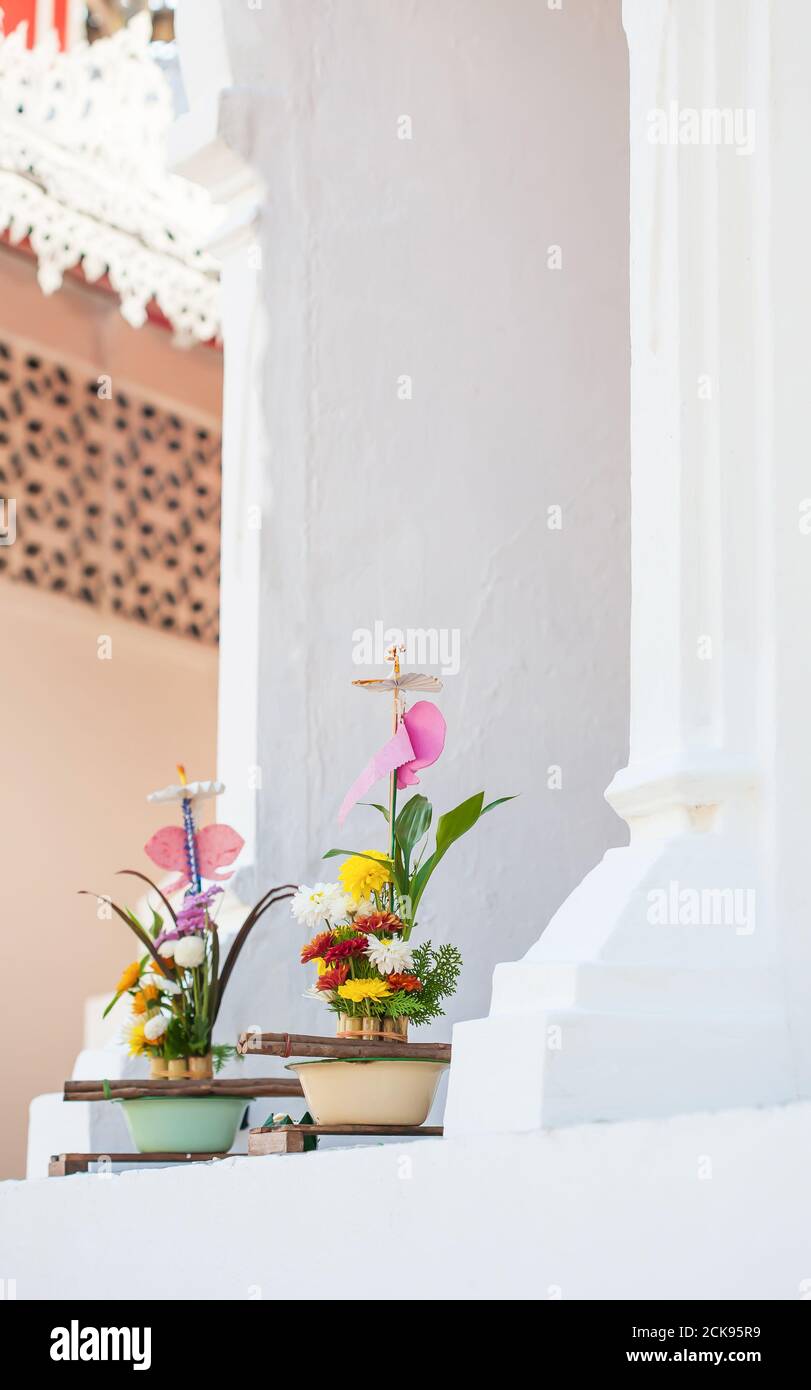Traditional flowers offerings to buddha at ancient pagoda, the belief is that the offering appeases the spirits, leading to merit and enlightenment. Stock Photo