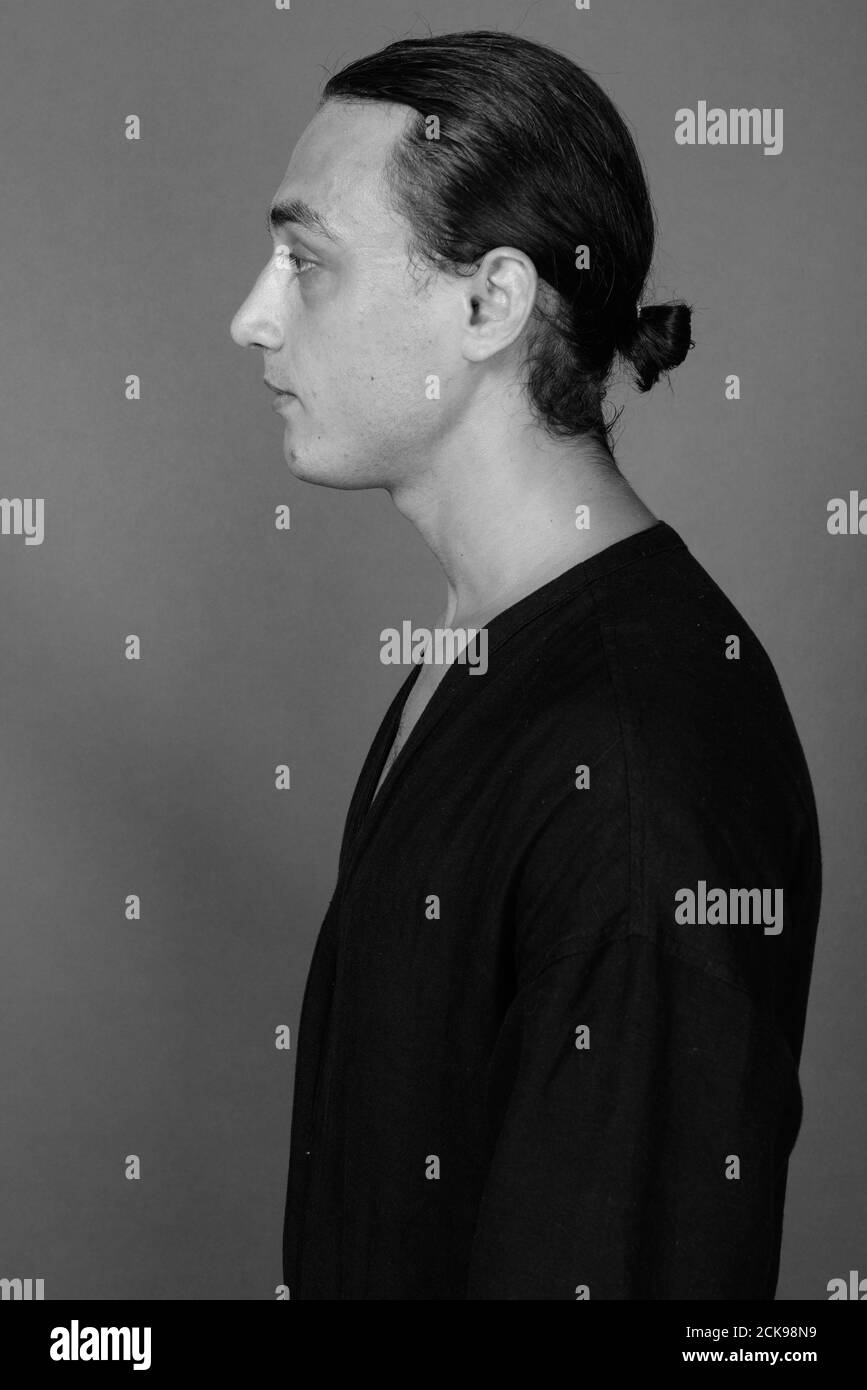 Portrait of young handsome man against gray background Stock Photo - Alamy