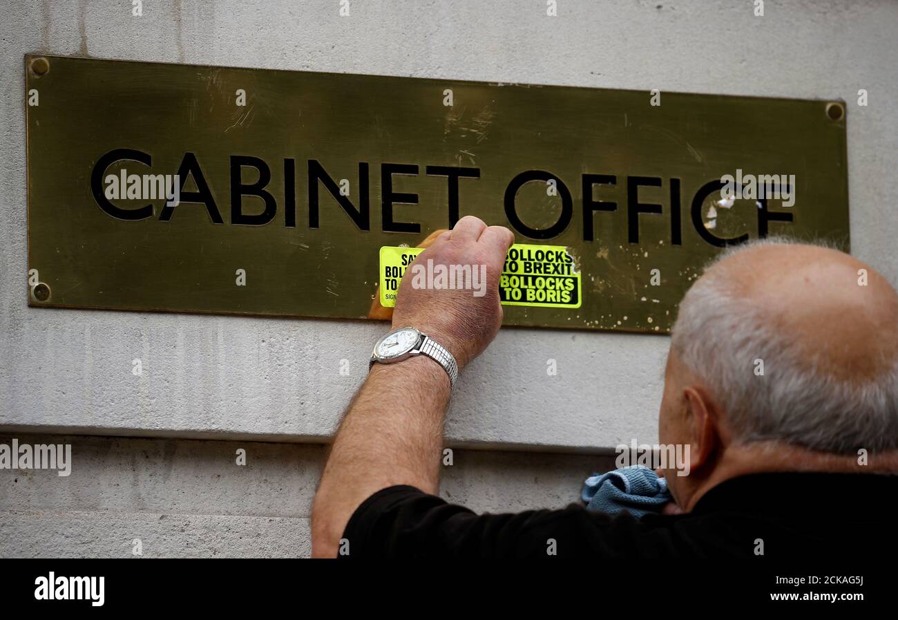 A worker removes anti-Brexit stickers from a sign at the Cabinet Office in London, Britain July 22, 2019.  REUTERS/Henry Nicholls Stock Photo