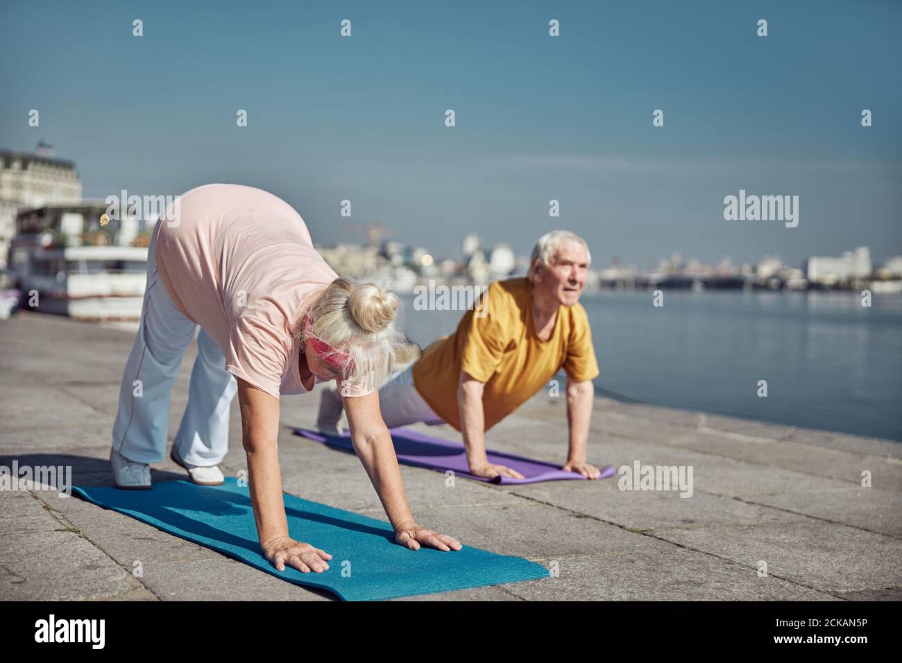 Sporty pensioners working out on the quay Stock Photo