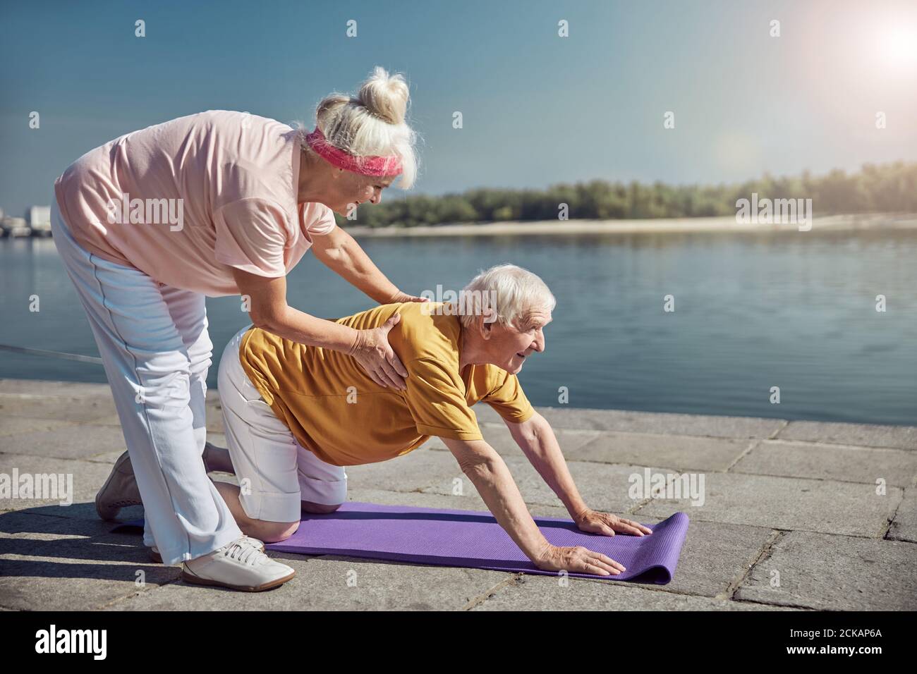 Smiling senior beginner yogi working out outside Stock Photo