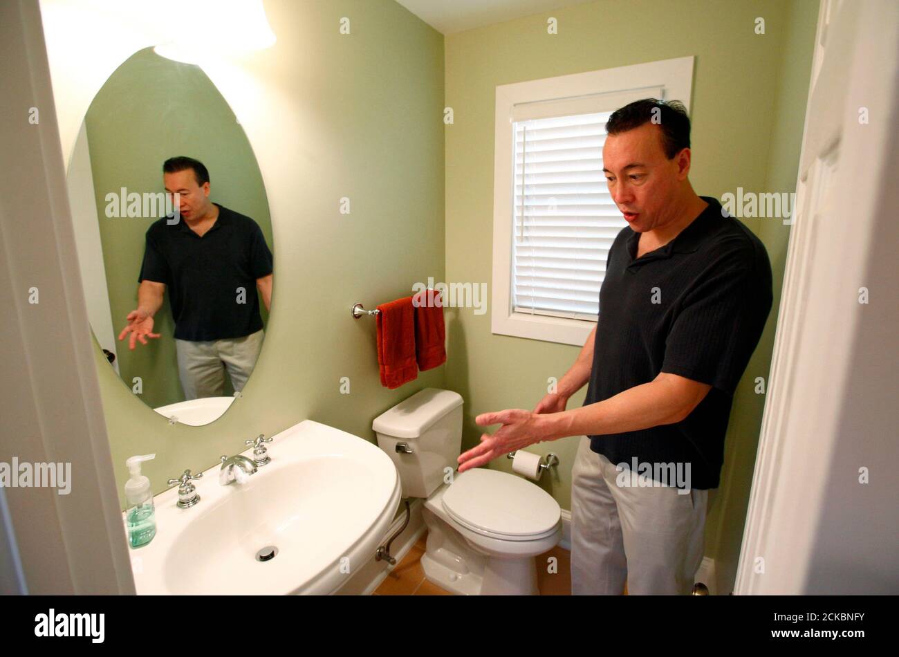 Real estate investor Lance Young describes to visitors the bathroom renovations that he has done in one of the distressed houses that he has purchased to renovate and resell in the Washington suburb of Arlington, Virginia, June 29, 2011. Young buys several discounted or distressed houses a year and then tries to make a substantial profit after performing major renovations on them. Often blamed for helping to create the U.S. housing boom and crash by driving up prices, investors are now welcomed as a key support for the battered property market. Picture taken June 29, 2011. To match Feature USA Stock Photo