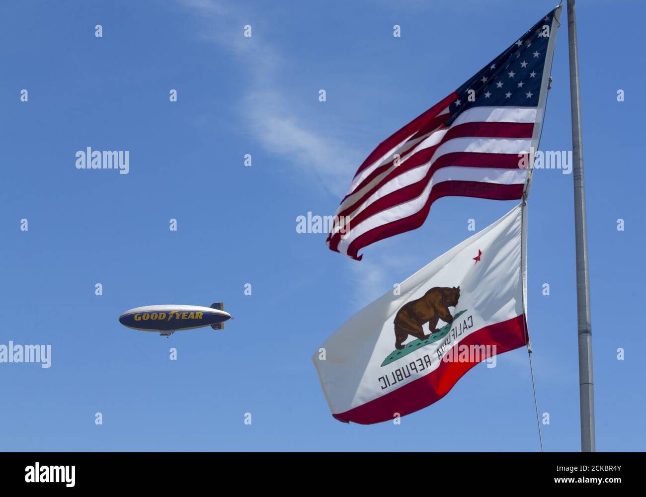 The Goodyear blimp ' Spirit of America' flies past flags in Carson, California August 5, 2015. Christened in 2002, the air ship is being retired after 8,000 flights and replaced with a newer more modern version named the  â€œSpirit of Innovationâ€? in September.    REUTERS/Mike Blake Stock Photo