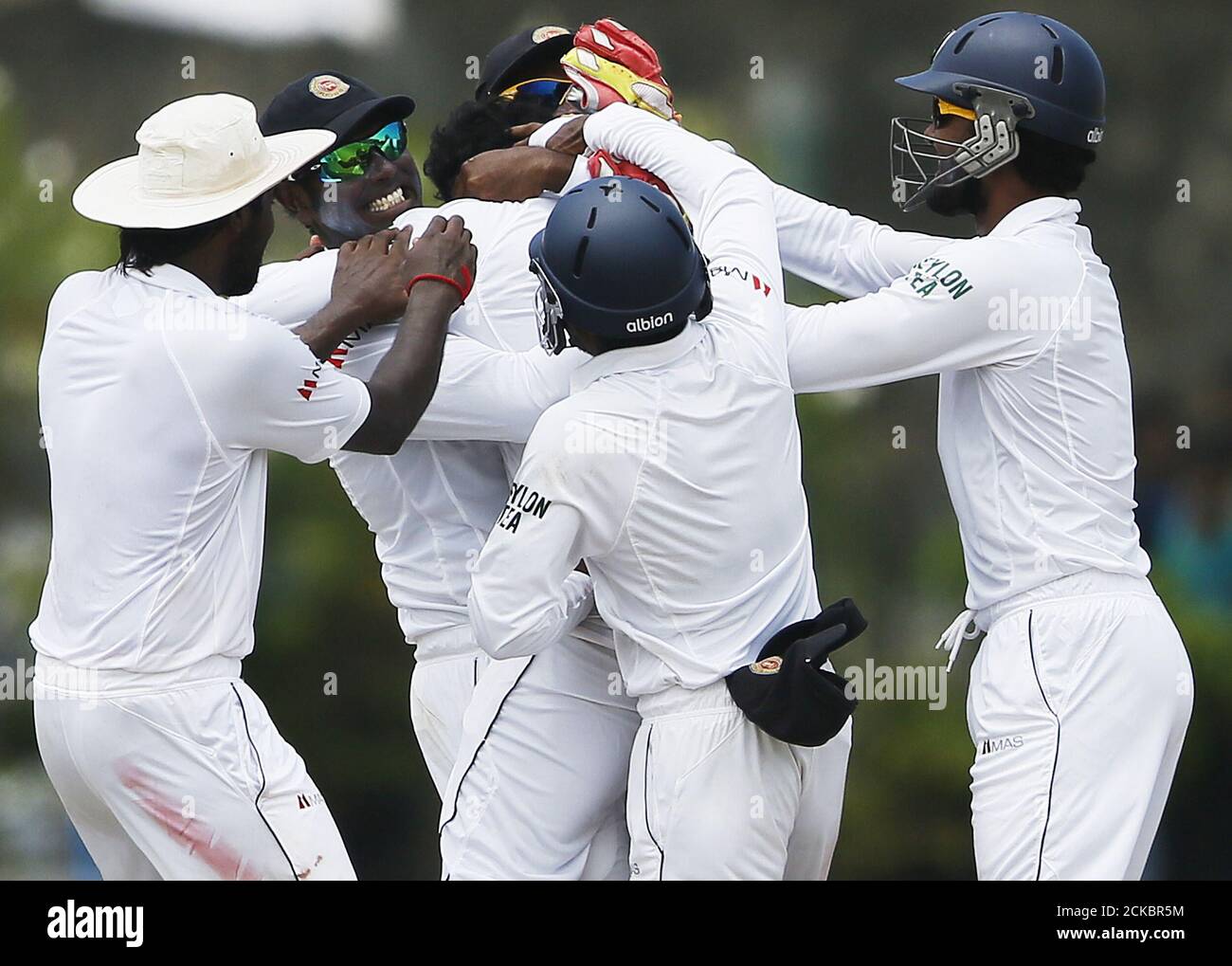 Sri Lanka's Tharindu Kaushal (C) celebrates with captain Angelo Mathews (2nd L) and Dinesh Chandimal (R) after taking the wicket of India's Shikhar Dhawani (not pictured) during the fourth day of their first test cricket match against Sri Lanka in Galle August 15, 2015. REUTERS/Dinuka Liyanawatte Stock Photo