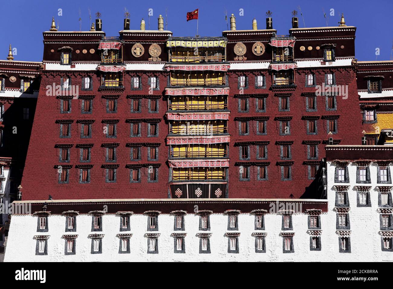 A Chinese flag flutters over the Potala Palace in Lhasa, Tibet Autonomous Region, China November 17, 2015. The Potala Palace, once the seat of Tibetan government and traditional residence of Dalai Lama, is a 13-storey palace with more than 1000 rooms. More than 1,300 years old, the palace is more than 3,700 meters above sea level and is a UNESCO World Heritage site. REUTERS/Damir Sagolj Stock Photo