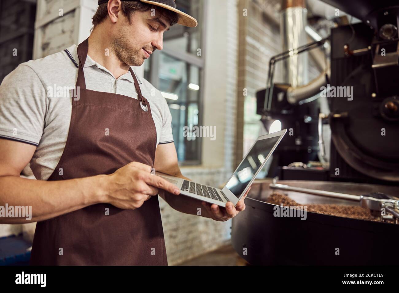 Handsome young man roaster using laptop at work Stock Photo Alamy