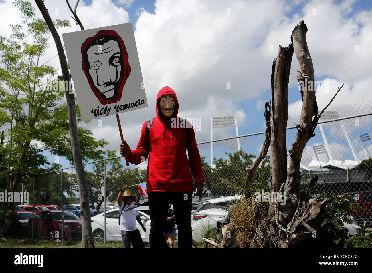 A demonstrator dressed as actors of "La Casa de Papel (Money Heist)" series holds a sign that reads "Ricky resign" during a protest calling for the resignation of Governor Ricardo Rossello in San Juan, Puerto Rico July 22, 2019. REUTERS/Marco Bello Stock Photo