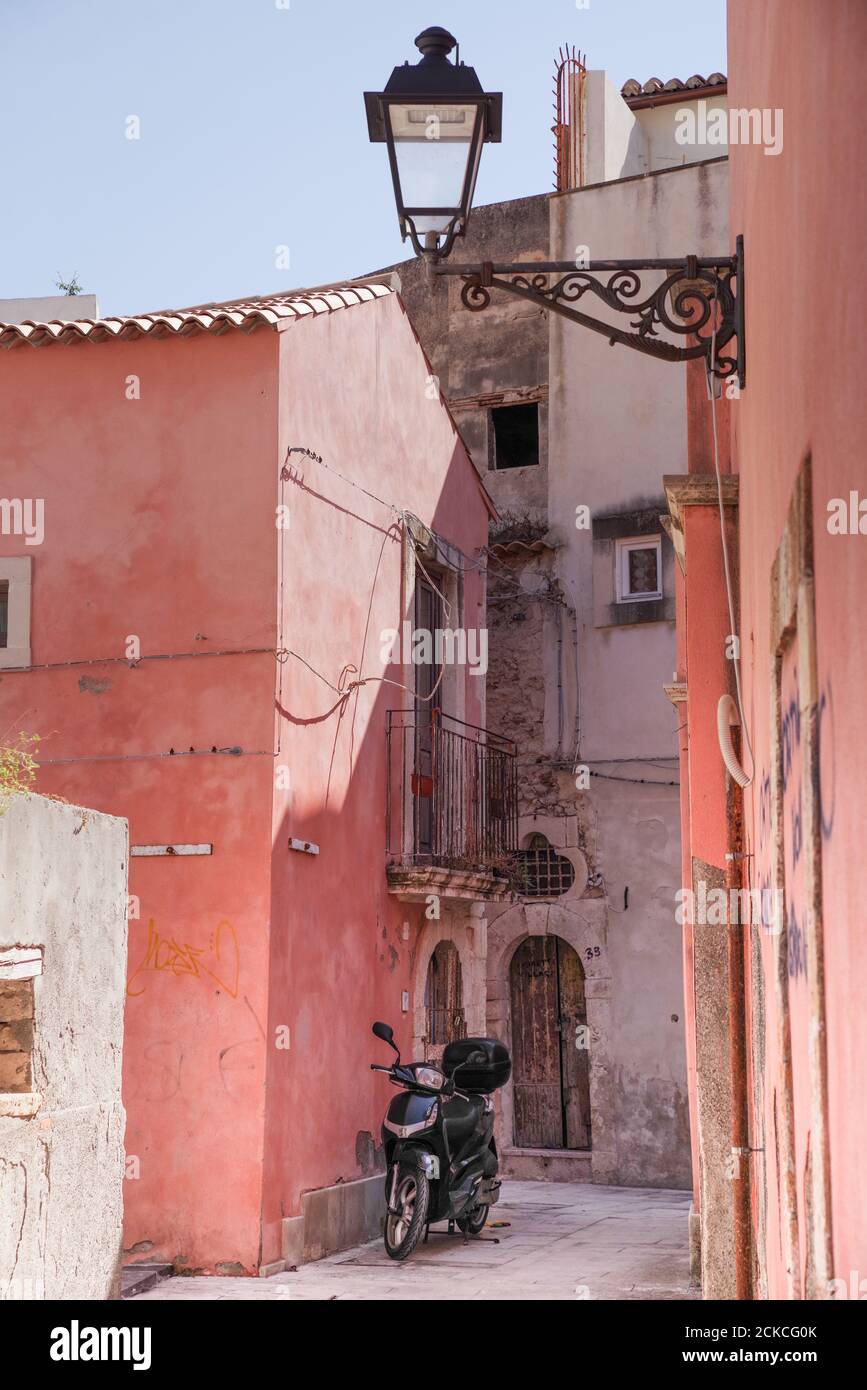 Moped parked outside a charming old house in Ortygia - Sicily, Italy Stock Photo