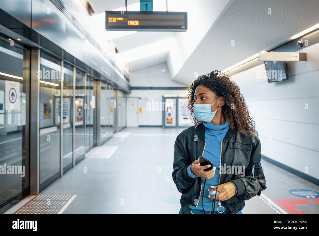 Black woman traveling on public transport and wearing face mask during