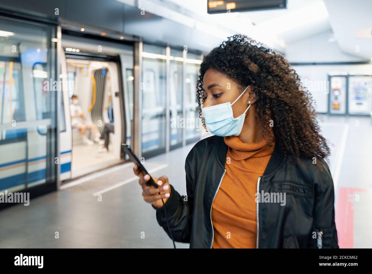 Black woman traveling on public transport and wearing face mask during ...