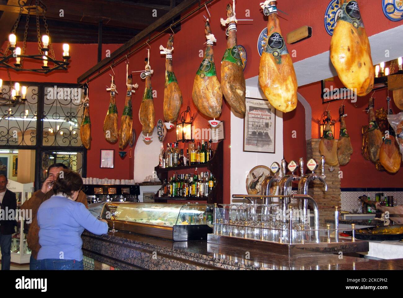 Interior of a typical Spanish bar with legs of cured ham hanging from