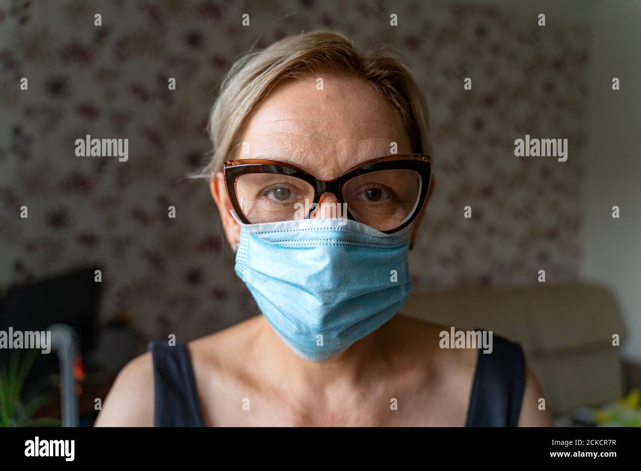 Caucasian woman with medical mask at home. Loneliness, mental health in ...