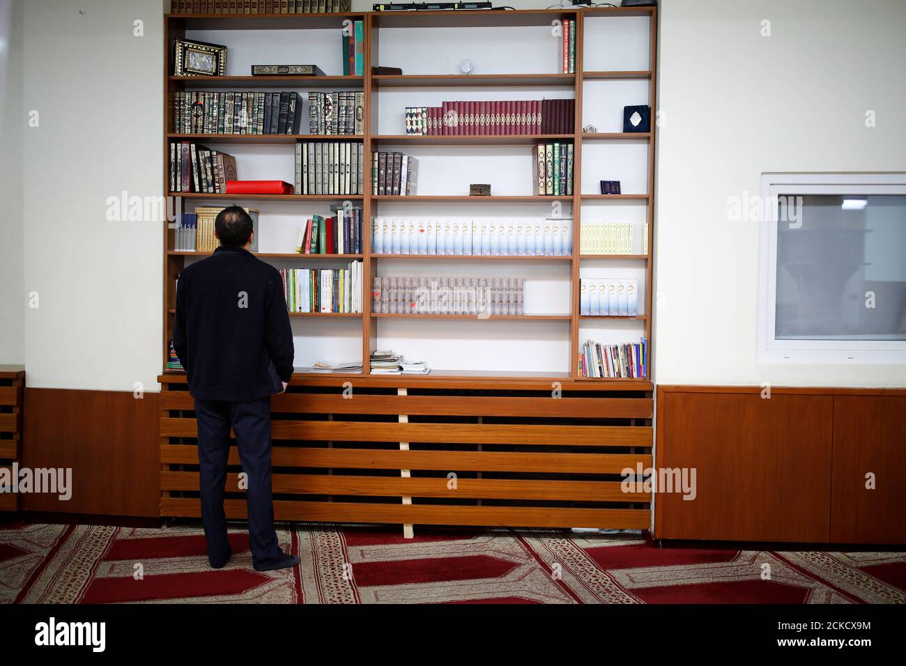 A man is looking at books inside the Dar al Salam Mosque, managed by NBS-Neukoellner Begegnungsstaette e.V. in Berlin, Germany October 3, 2017.   REUTERS/Axel Schmidt Stock Photo