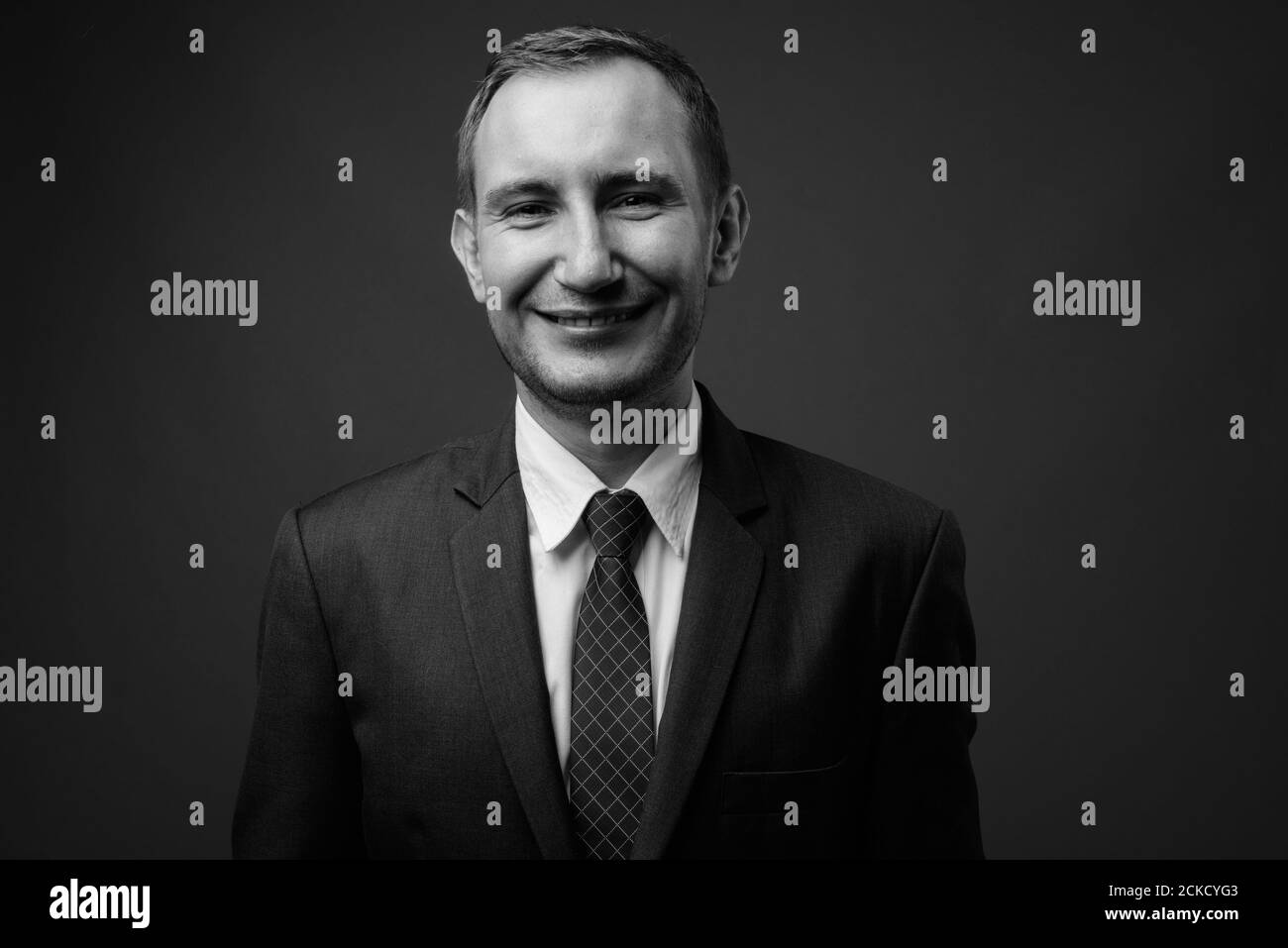 Portrait of businessman in suit against gray background Stock Photo - Alamy