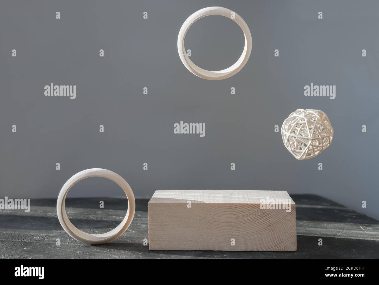 minimal style wooden podium or pedestal for product presentation. wooden display and flying rings for advertising your natural eco product. scandinavian style composition. Stock Photo