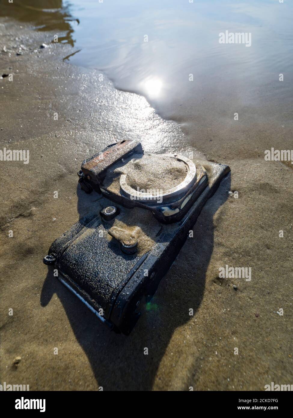 Nikon retro classic SLR film camera body on beach sun bright reflection sunshine sunlight Stock Photo