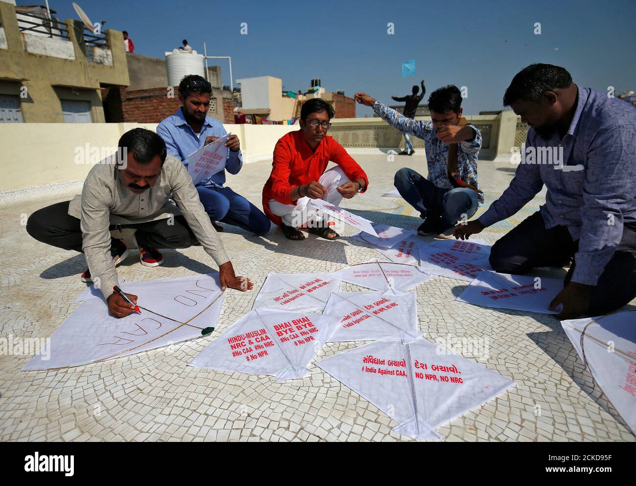 People prepare kites with messages before flying them, as part of a