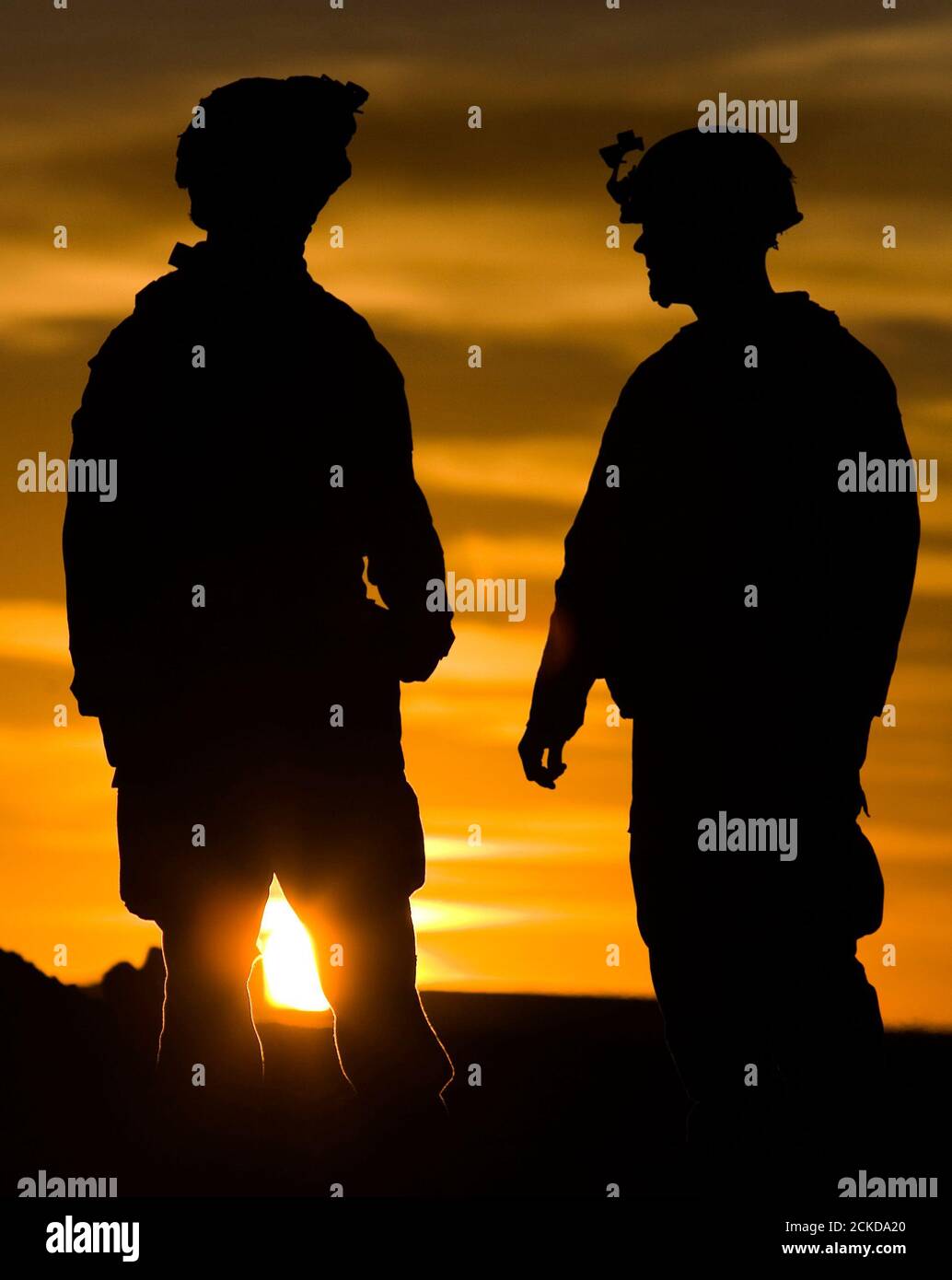 U.S. Marines from 3rd Battalion 4th Marines talk during sunset at base Delaram in Nimroz province, southern Afghanistan January 13, 2010. REUTERS/Marko Djurica (AFGHANISTAN - Tags: MILITARY CONFLICT) Stock Photo