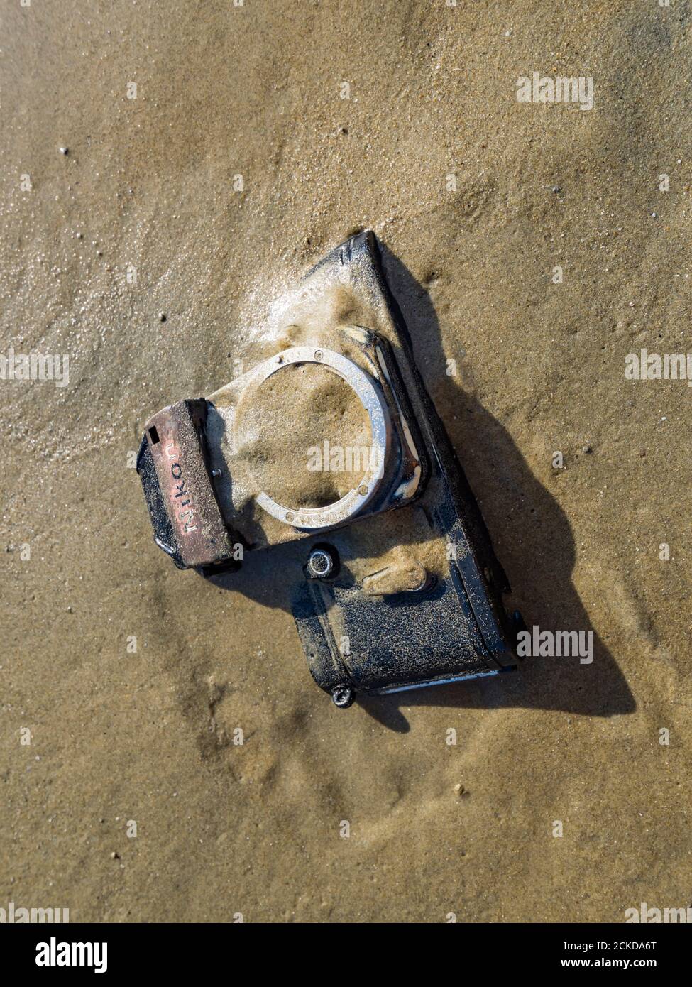 Nikon retro classic SLR film camera body on beach sun bright reflection sunshine sunlight Stock Photo