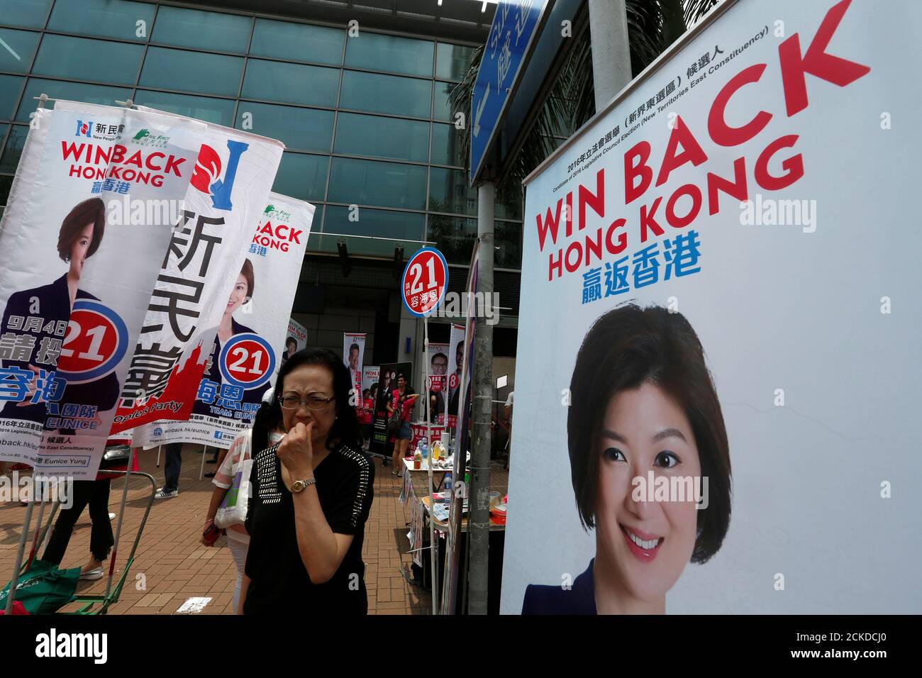 A woman walks past campaign banners of candidate Yung Hoi-yan from New  Peoples Party on