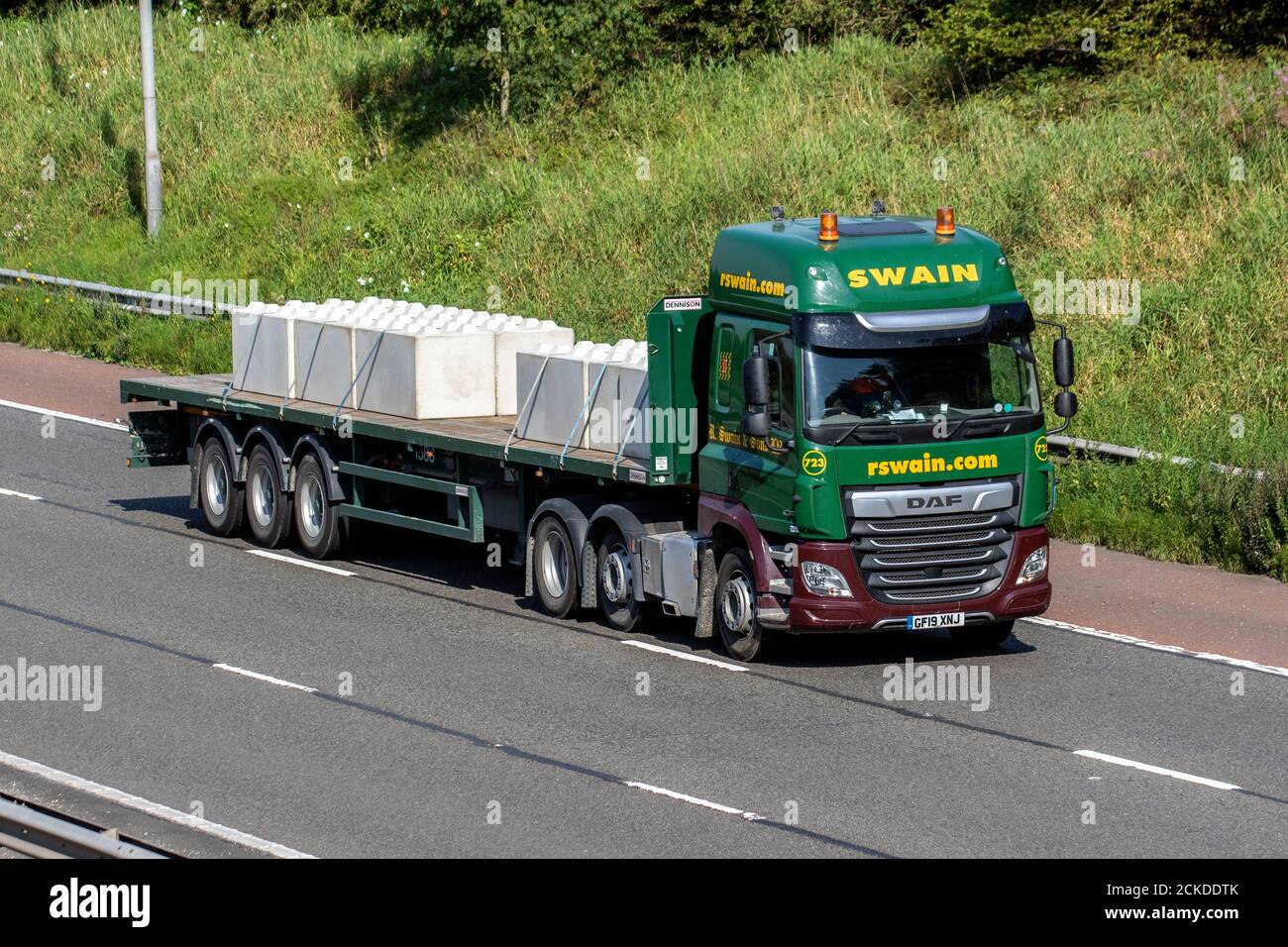 Swain Haulage delivery trucks, low-loader lorry, transportation, truck, cargo carrier, DAF vehicle, European commercial transport industry HGV, M6 at Manchester, UK Stock Photo