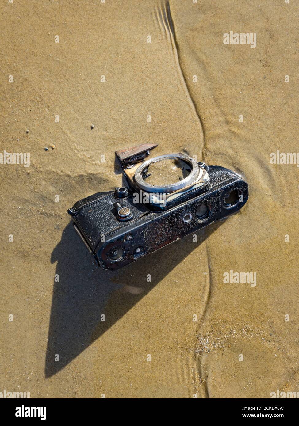 Nikon retro classic SLR film camera body on beach Stock Photo