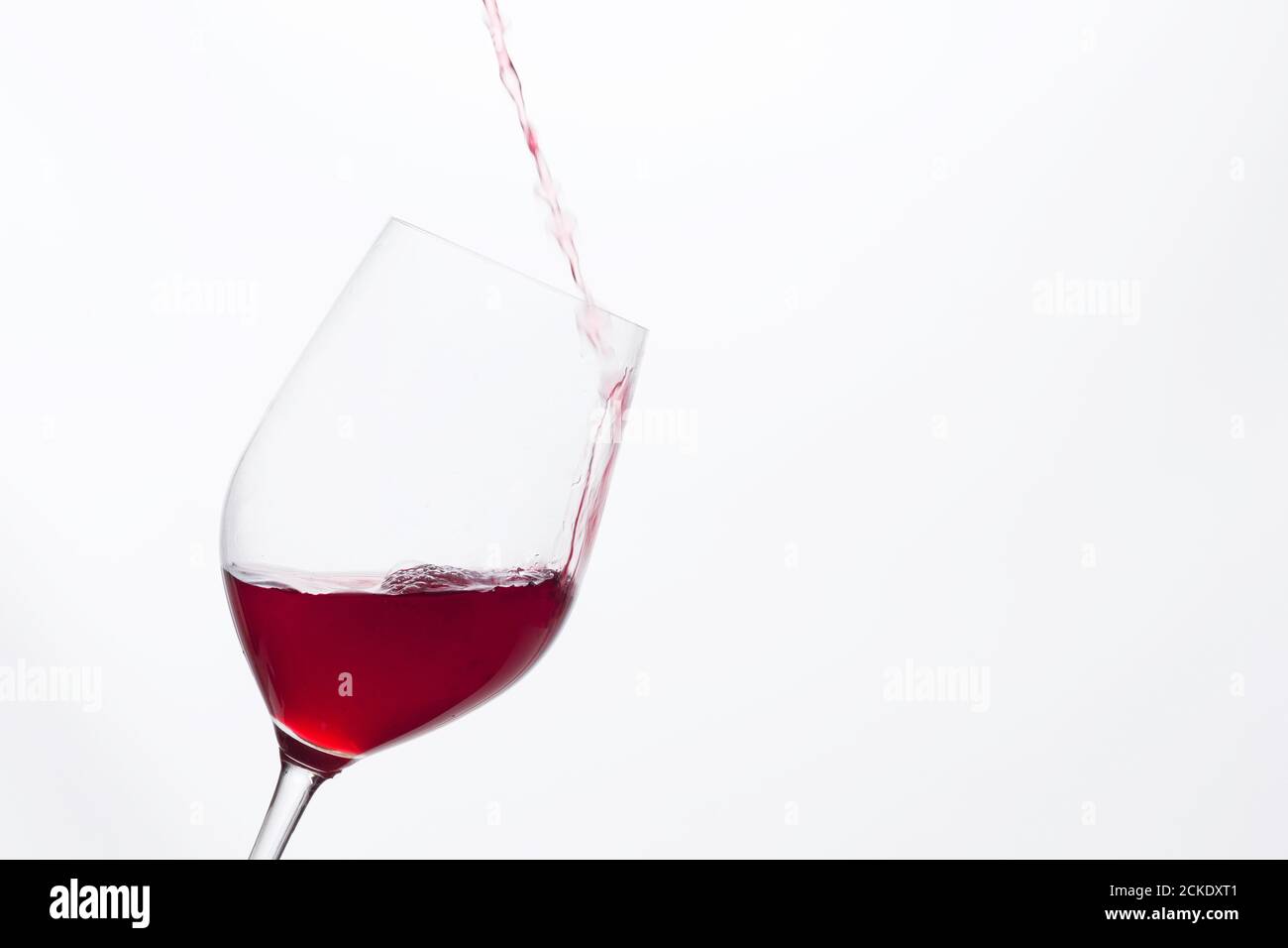 filling a wine glass, red wine falling into a transparent crystal wine