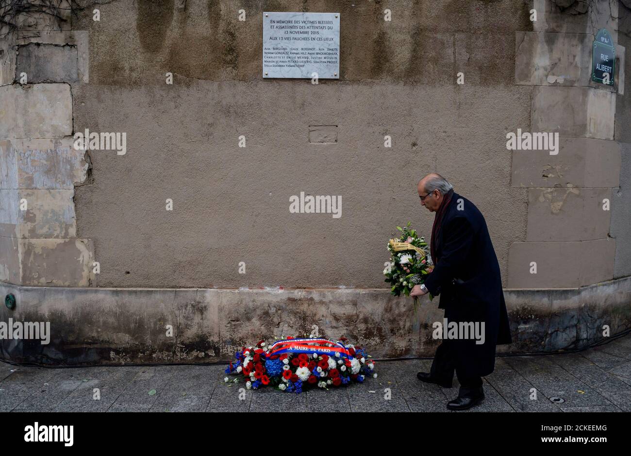 A man pays respects under a commemorative plaque unveiled by French President Francois Hollande and Paris Mayor Anne Hidalgo next to the 'Le Carillon' and 'Le Petit Cambodge' bars and restaurants, in Paris, France, November 13, 2016, during a ceremony held for the victims of last year's Paris attacks which targeted the Bataclan concert hall as well as a series of bars and killed 130 people.    REUTERS/Christophe Petit Tesson/Pool Stock Photo