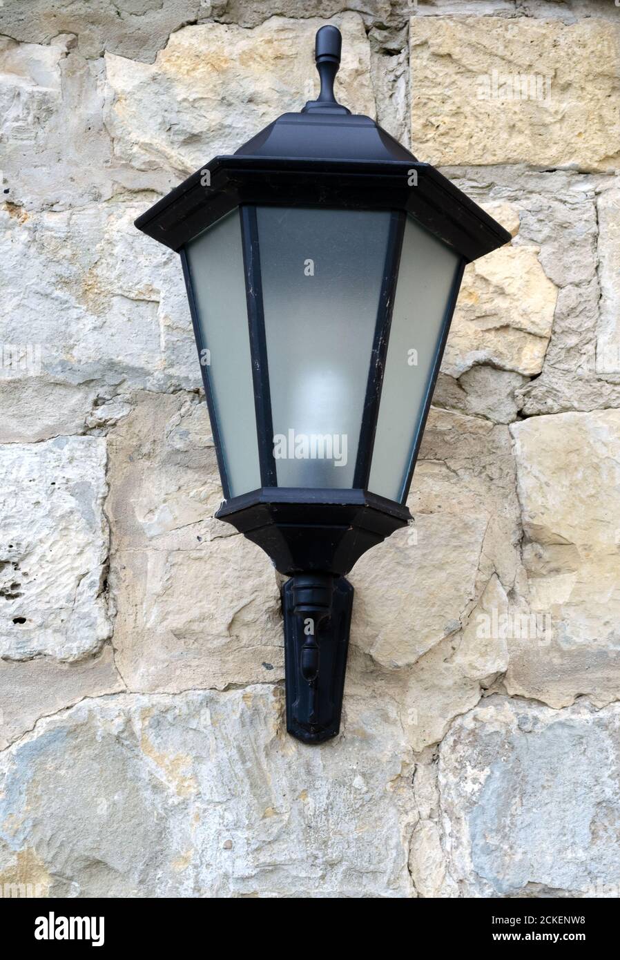 Close-up view of vintage lantern on stone wall Stock Photo