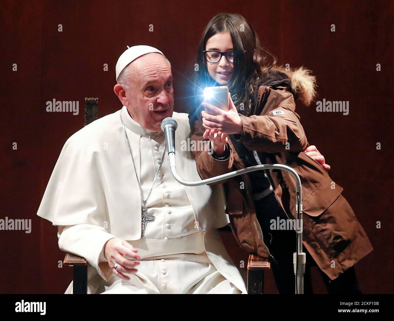 A girl takes a selfie with Pope Francis during a visit to the parish of St.