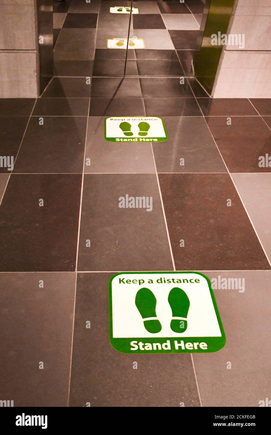 Footprint signage showing social distancing measures on the floor of an elevator. Stock Photo