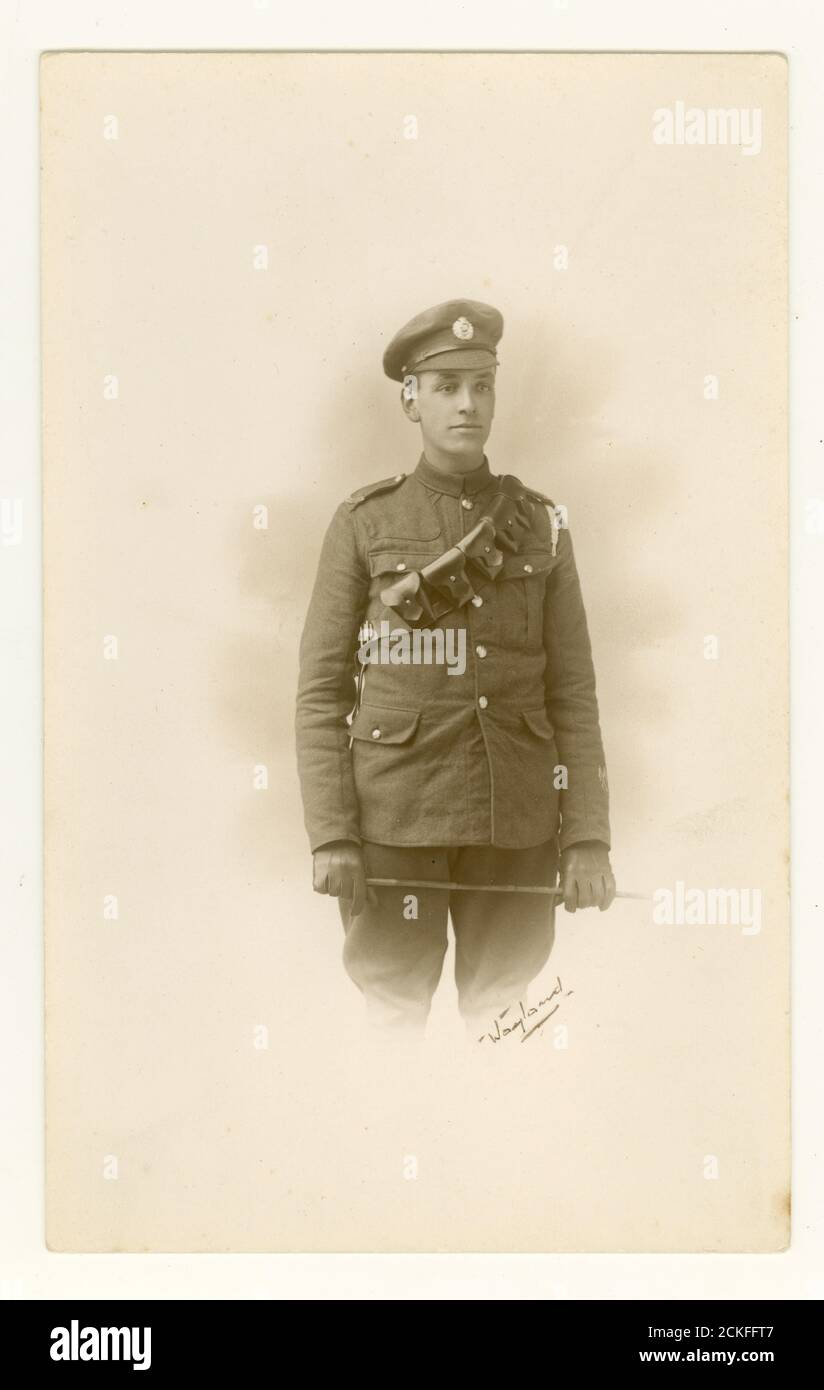 WW1 era studio portrait photograph of handsome young cavalry man soldier, wearing a bandolier or bullet belt, carrying a cane whip, Blackheath, London, England, U.K. 1914-.1918 Stock Photo