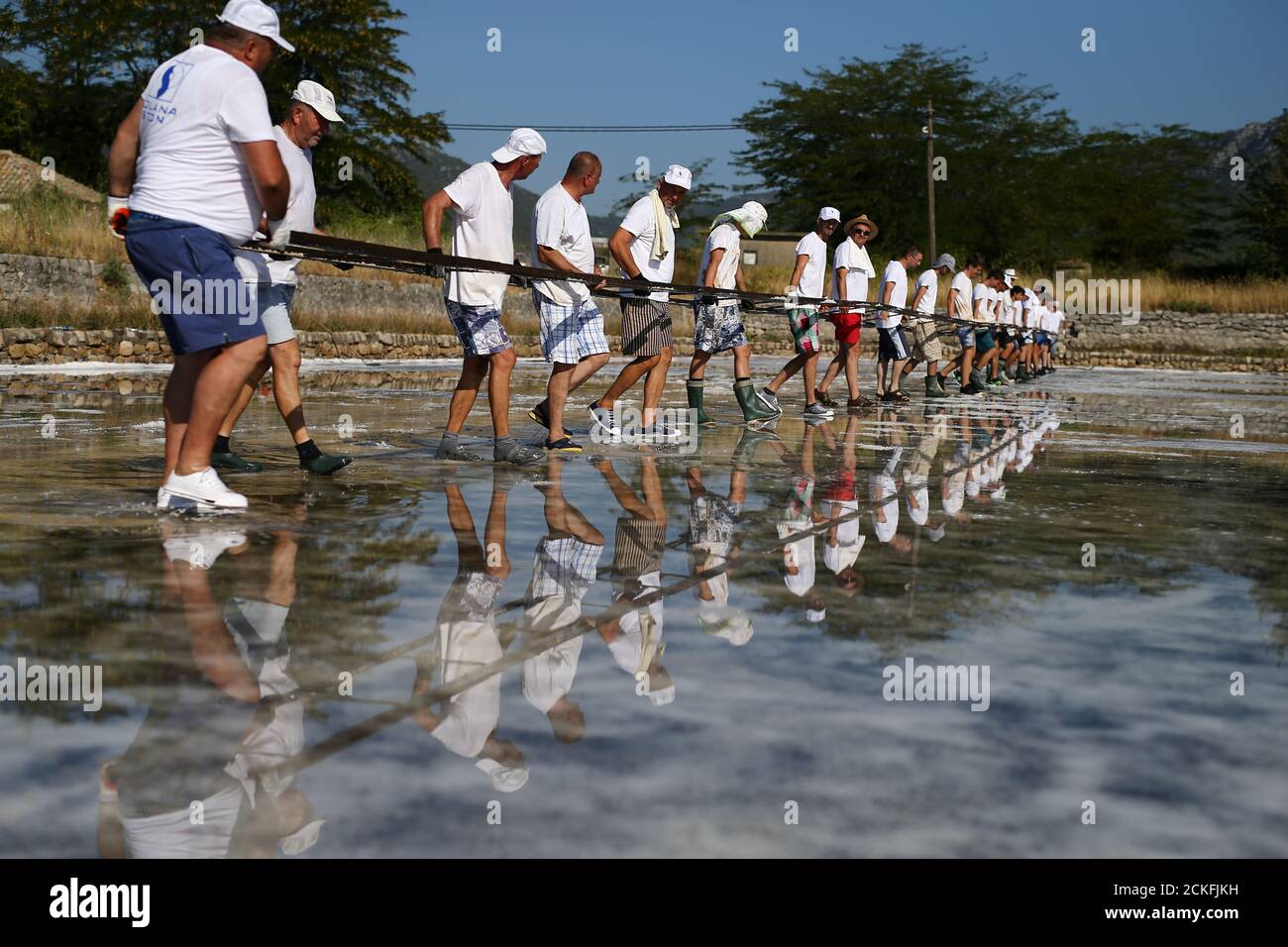A workers carry railways for wagons at the Ston Saltworks site in Ston,  Croatia, August 8,