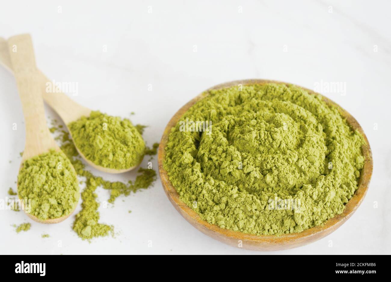 Moringa powder in wooden bowl with on white background. Healthy product ...
