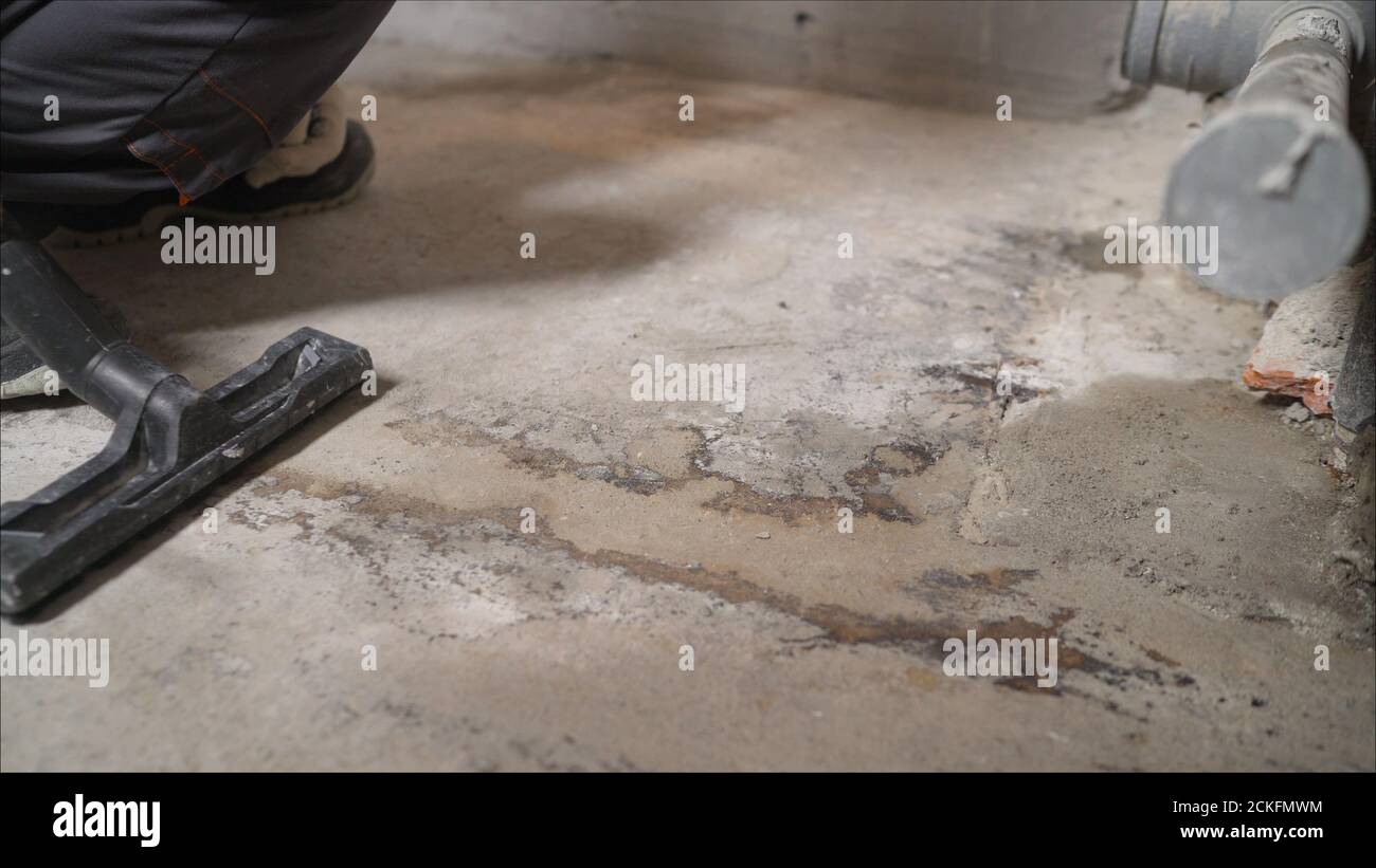 A worker vacuums a concrete floor with 
