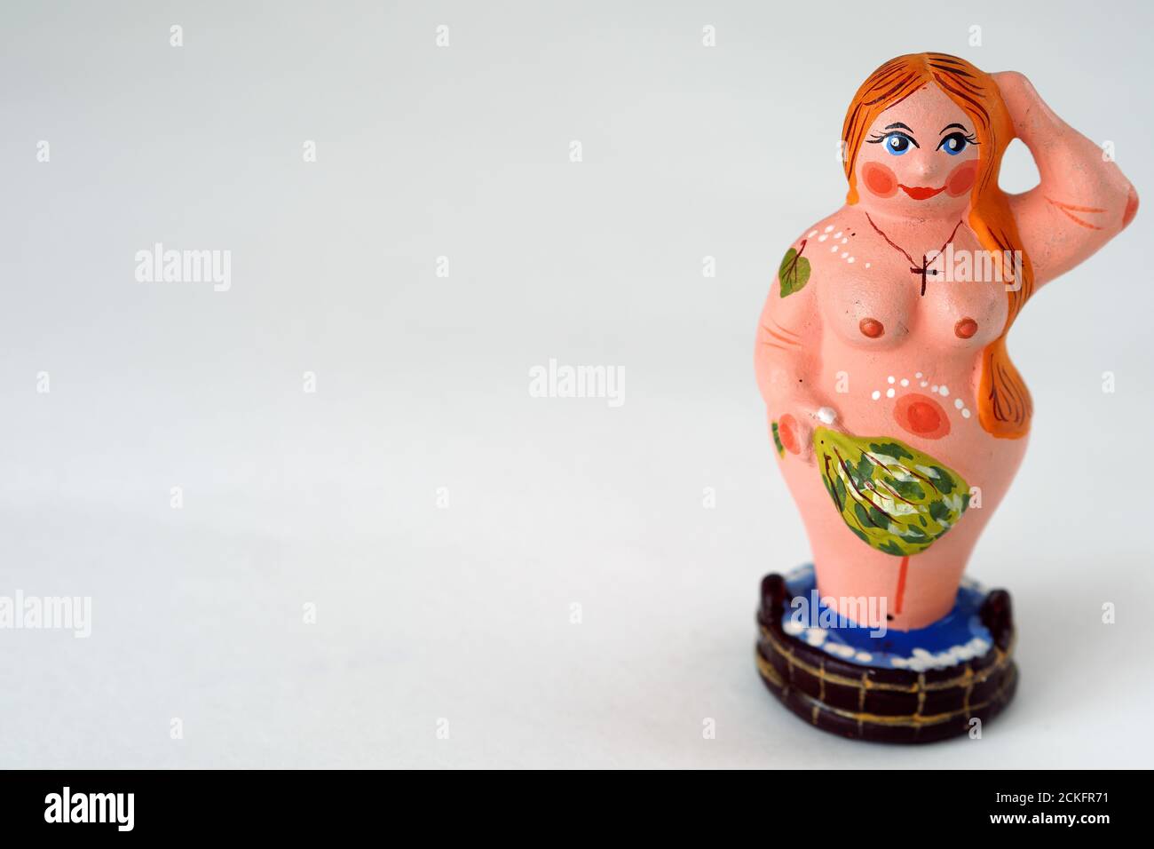 Funny figurine of ceramics, plaster and clay. A woman in a bath with a broom. Stock Photo