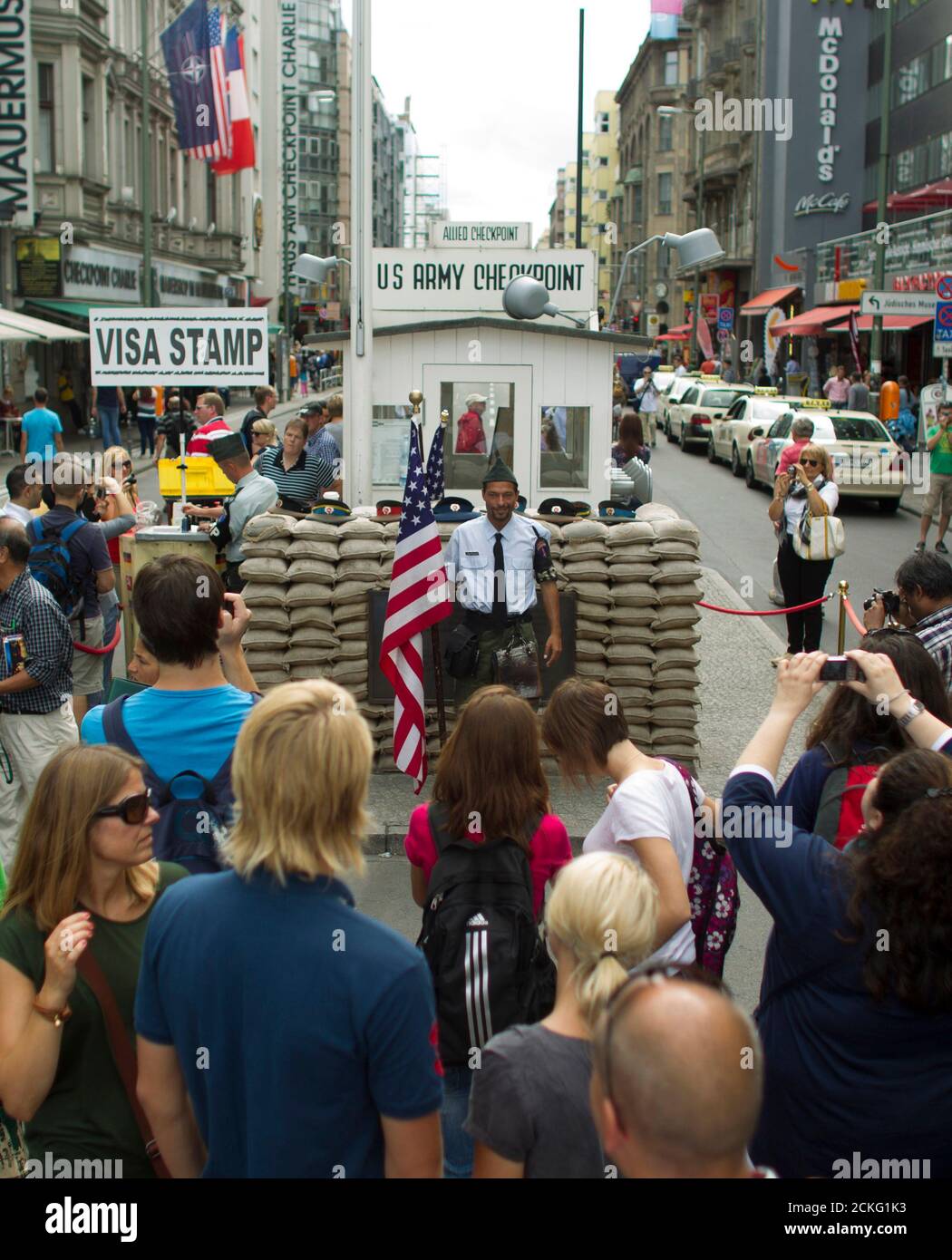 Tourists have their pictures taken at the former Checkpoint Charlie border crossing in Berlin, August 25, 2012.   More than two decades after the fall of the Berlin Wall, differences over how to represent the Cold War past are hampering plans to build a new museum at the former border crossing. Picture taken August 25, 2012. REUTERS/Thomas Peter (GERMANY  - Tags: TRAVEL SOCIETY POLITICS) Stock Photo