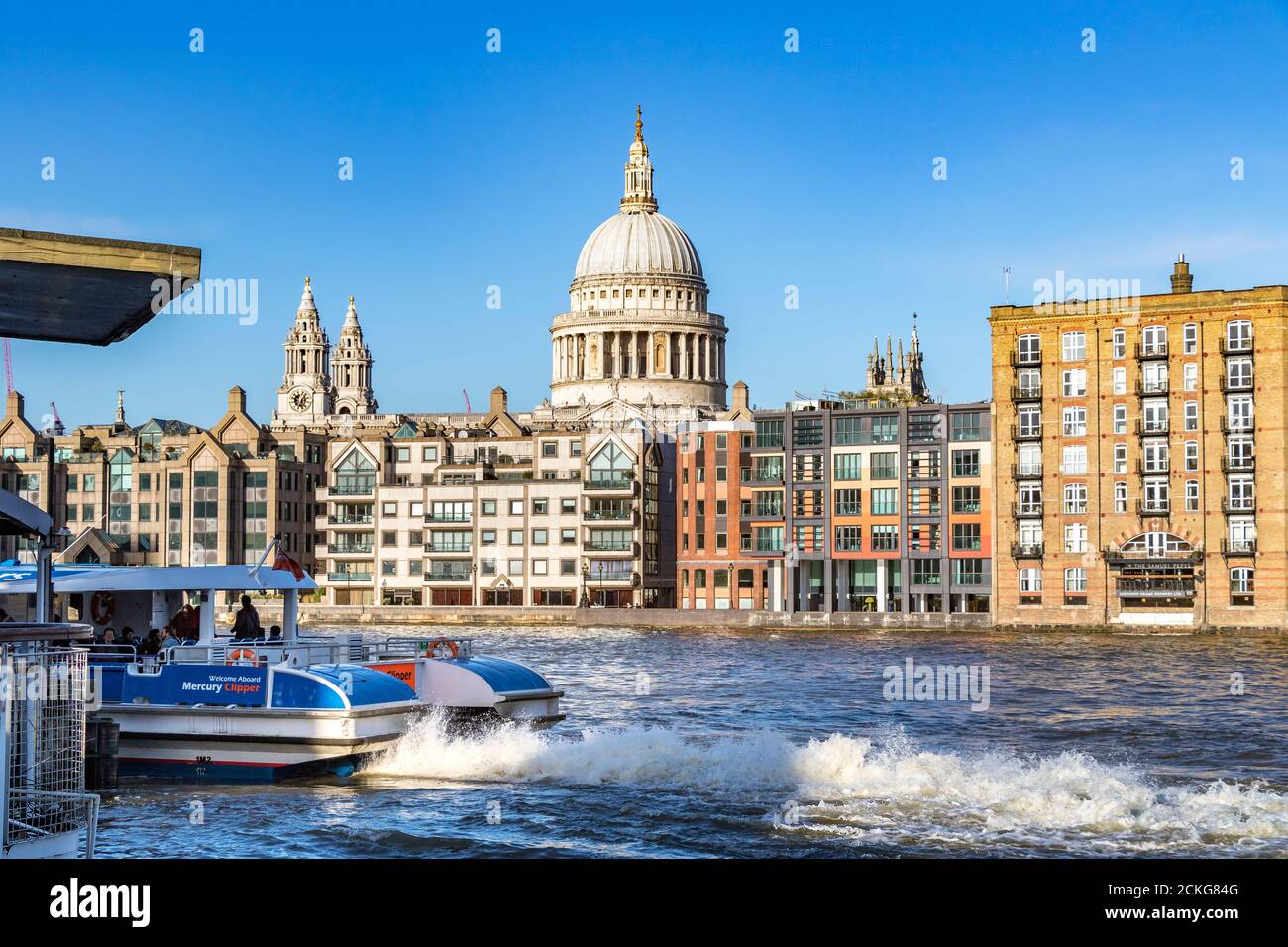 A Thames Clipper River Boat pulls up at Bankside River Boat stop with St. Paul's Cathedral and it's iconic dome in the background ,London ,UK Stock Photo