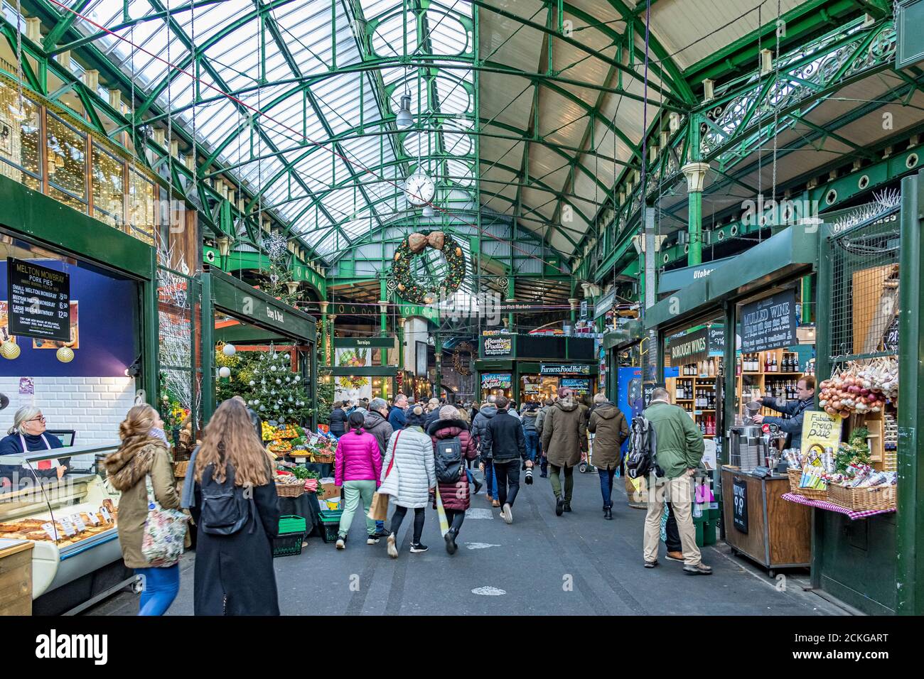 People shopping and browsing at the market stalls under the glass and wrought iron roof at Borough Market, Southwark,London Stock Photo