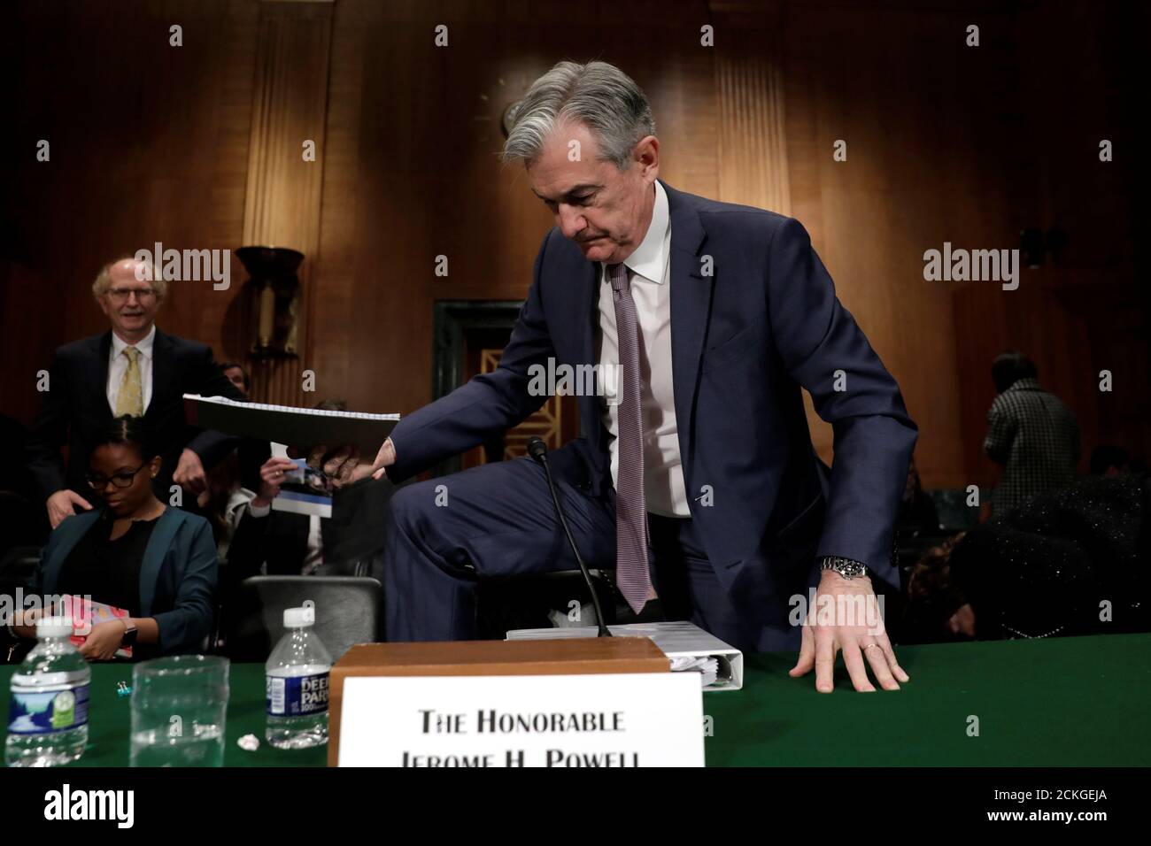 Federal Reserve Board Chairman Jerome Powell steps over a chair after a