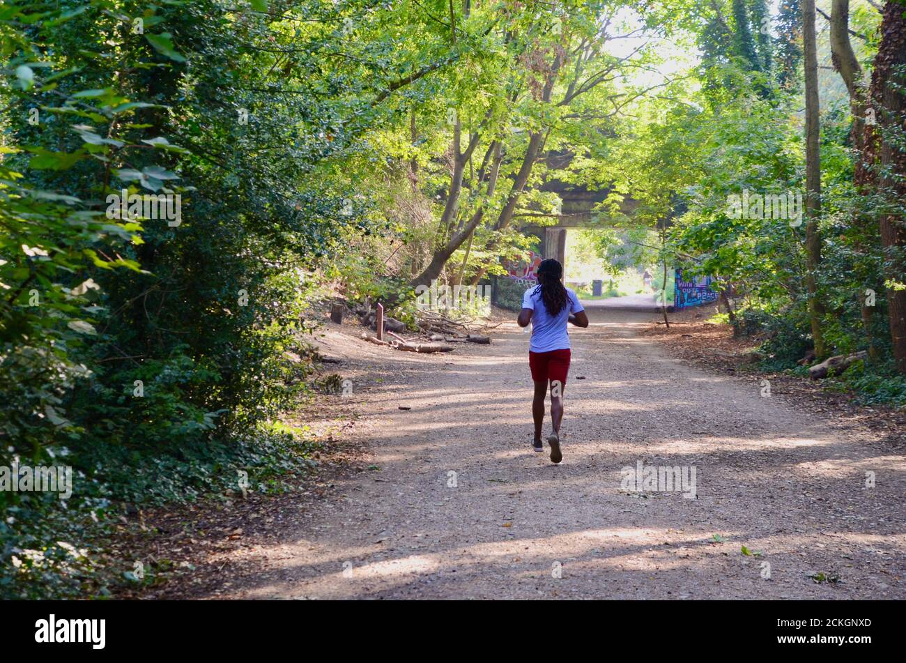 black jogger running through parkland walk south north london england
